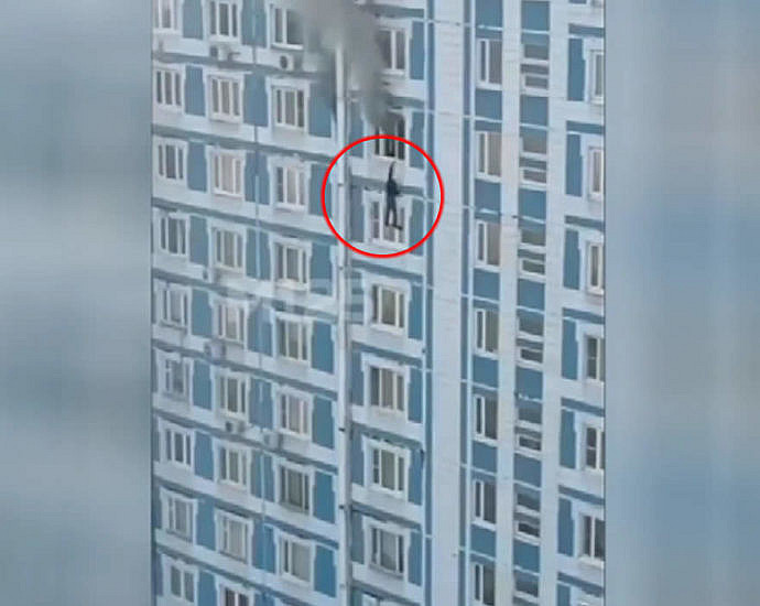 A man jumps from the window of a burning building