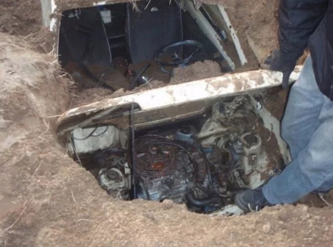 The components and assemblies of a car buried under the ground are absolutely intact