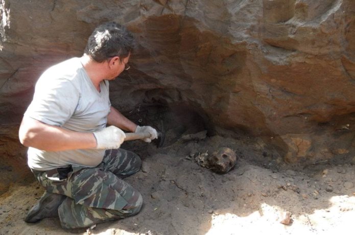 Volunteer digging up human remains