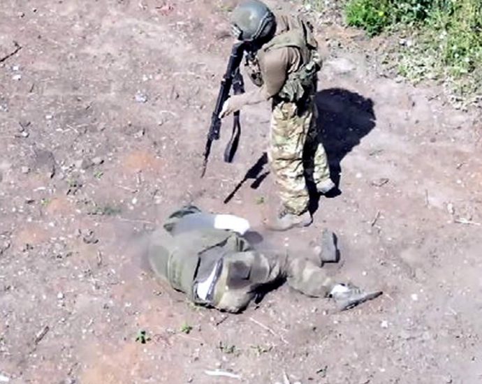 Russian soldier finishes off a wounded soldier