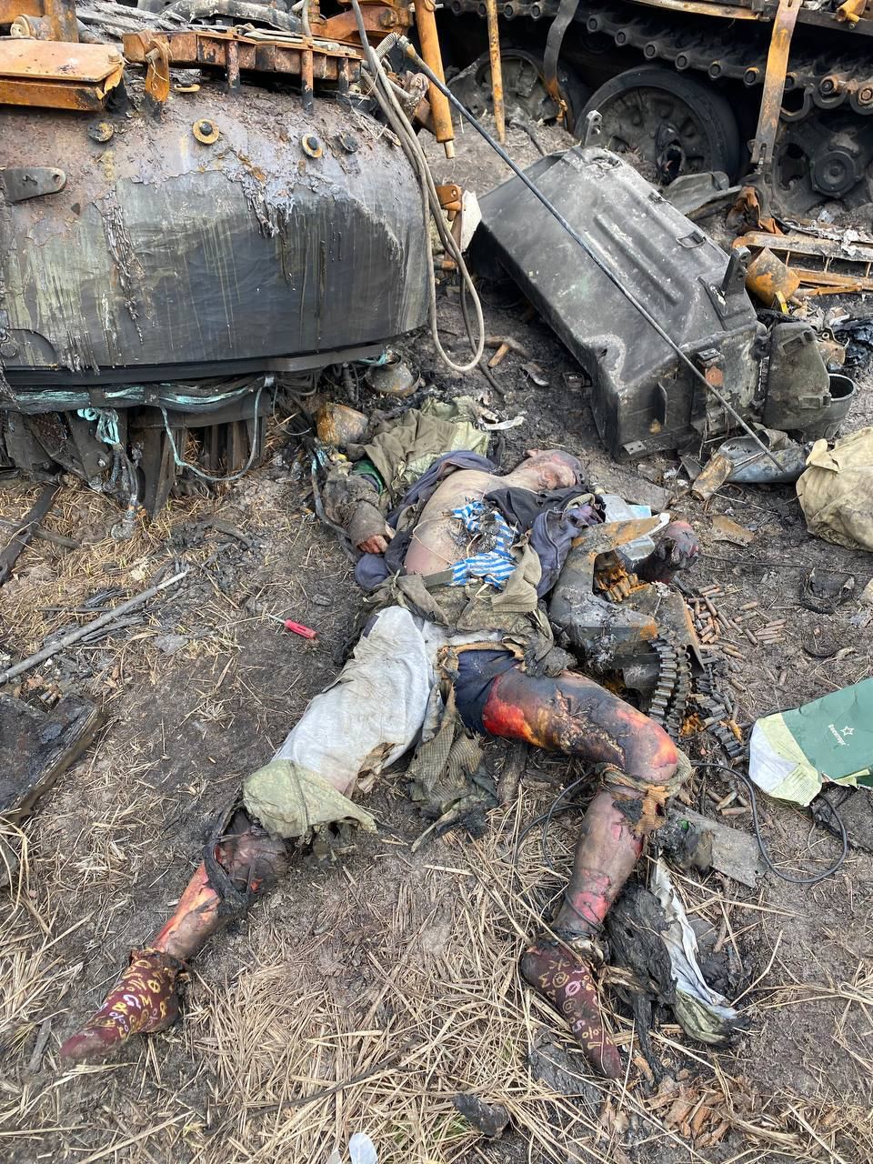 The corpse of a Russian military against the background of destroyed armored vehicles