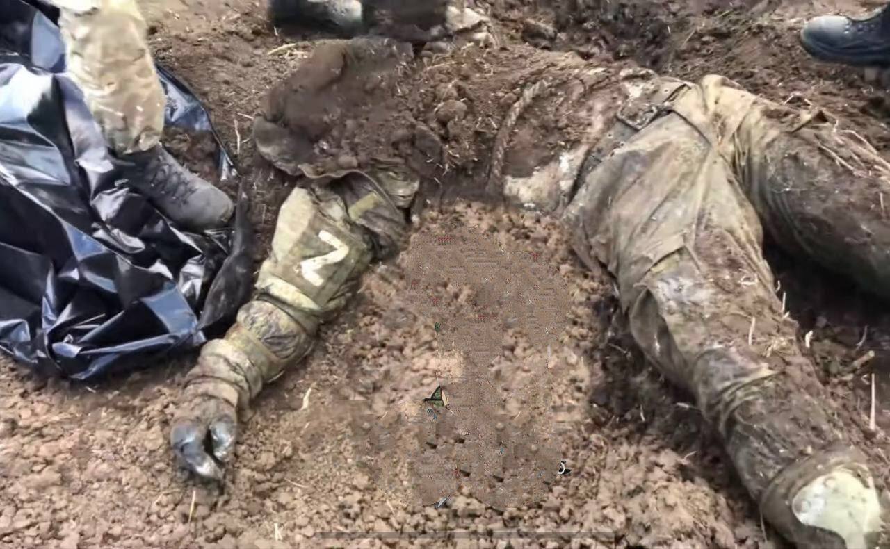 The corpse of a Russian soldier is sprinkled with earth